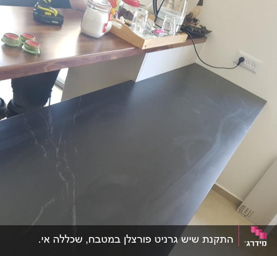 משטח שיש שחור עם גידים לבנים המותקן במטבח